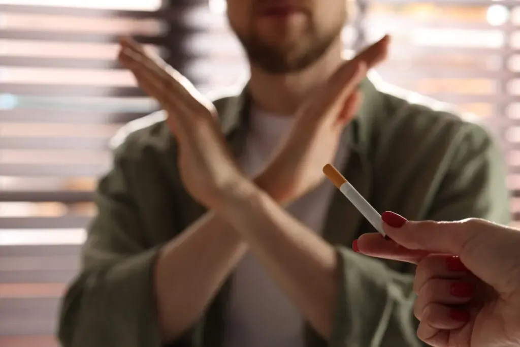 Man crossing his arms to refuse a cigarette, stop smoking support at Pan Pharmacy Birmingham