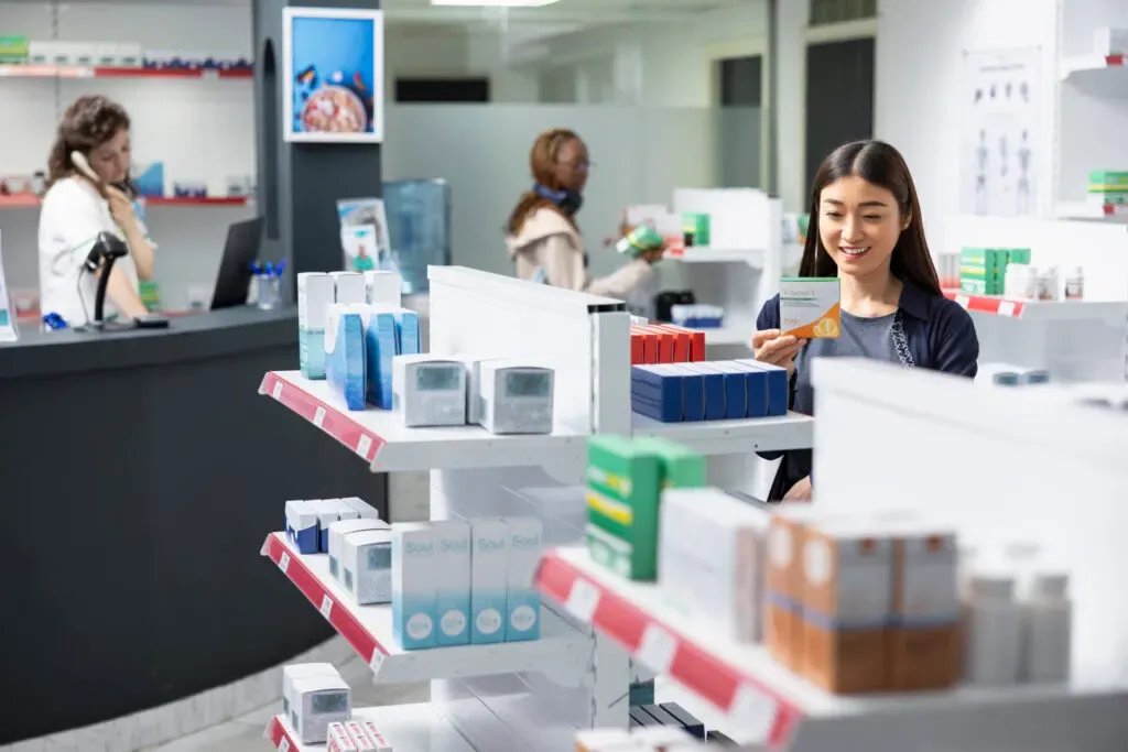 Customer browsing health products in a modern pharmacy at Pan Pharmacy Birmingham
