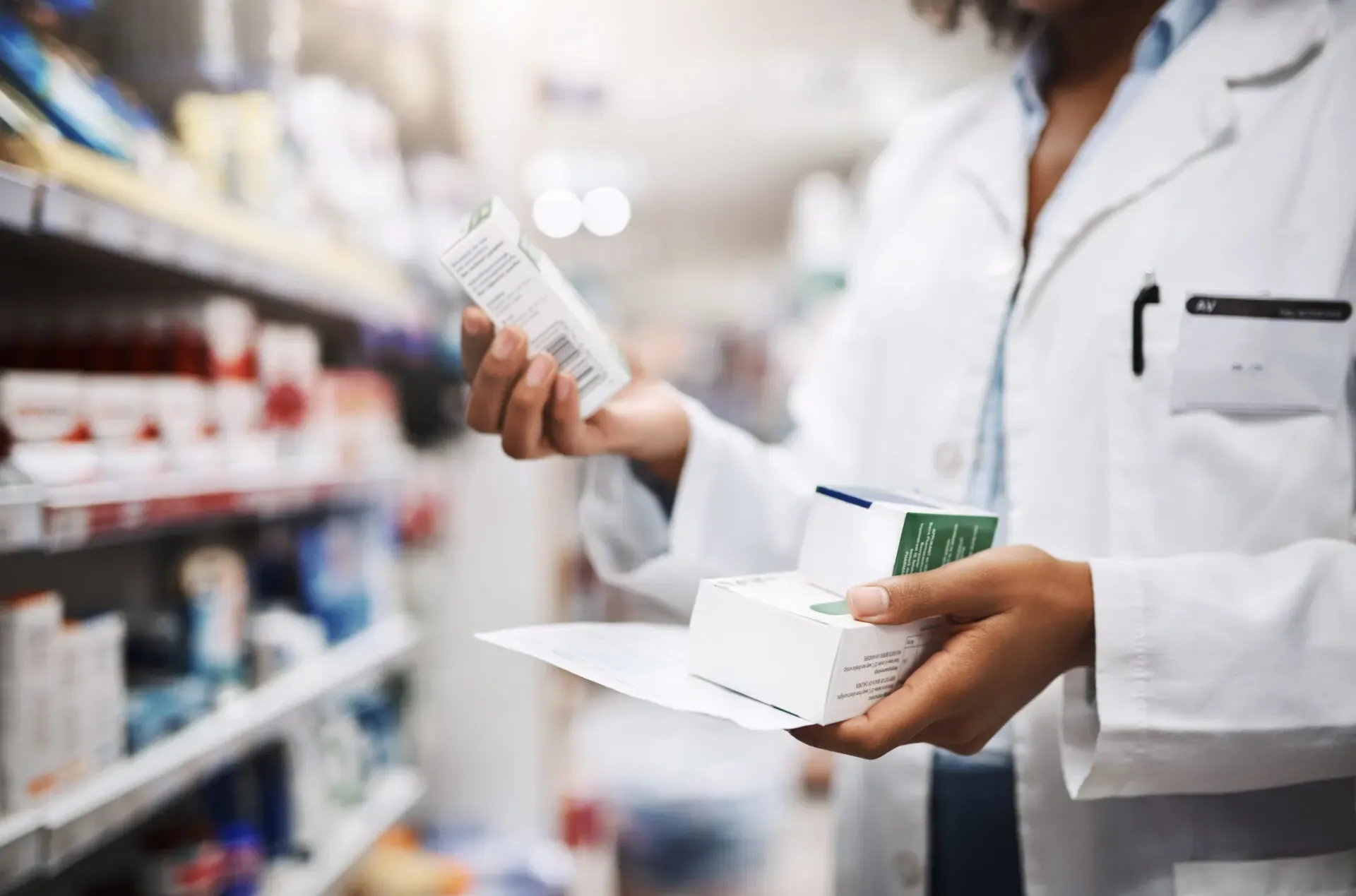 Pharmacist checking a medicine box in the pharmacy aisle, Pan Pharmacy – Church Road (The Radleys)