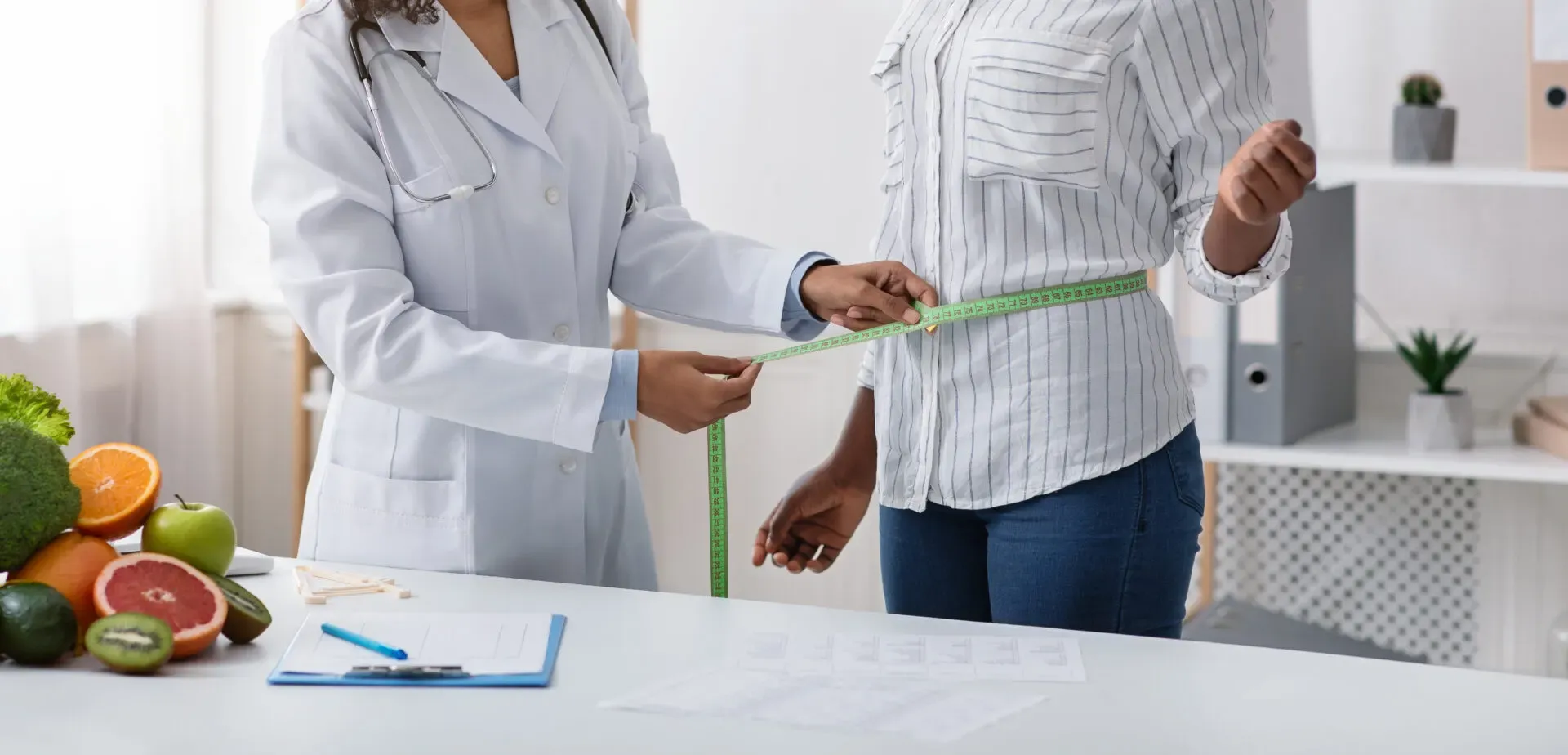 Clinician measuring a patient's waist during a weight loss consultation at Pan Pharmacy Birmingham