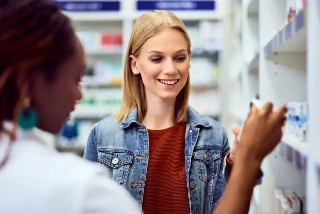 Pharmacist talking with a woman at the counter, women’s health support at Pan Pharmacy Birmingham