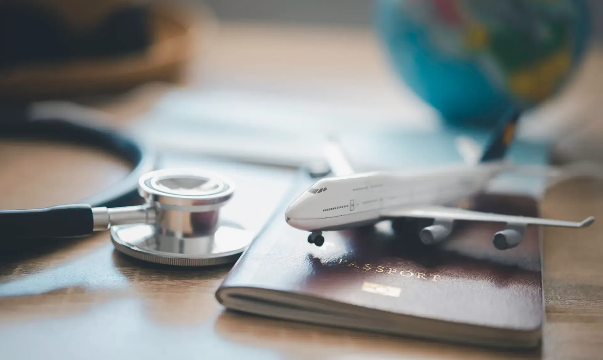 Passport, stethoscope and model aeroplane for the travel clinic at Pan Pharmacy Birmingham