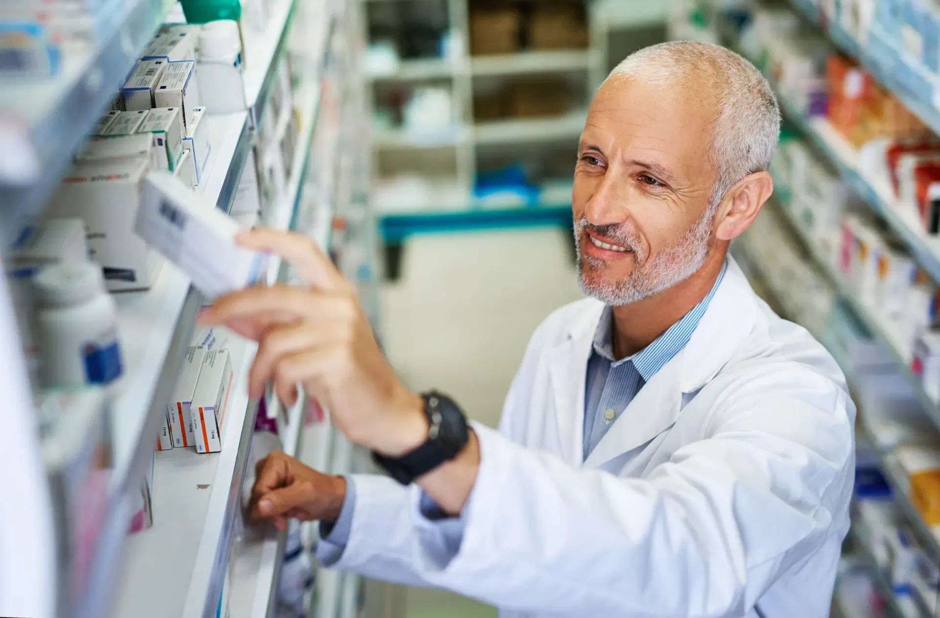Pharmacist checking products on the dispensary shelves, Pan Pharmacy – Coventry Road