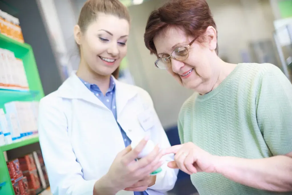 Pharmacist explaining medication to an older woman at Pan Pharmacy Birmingham