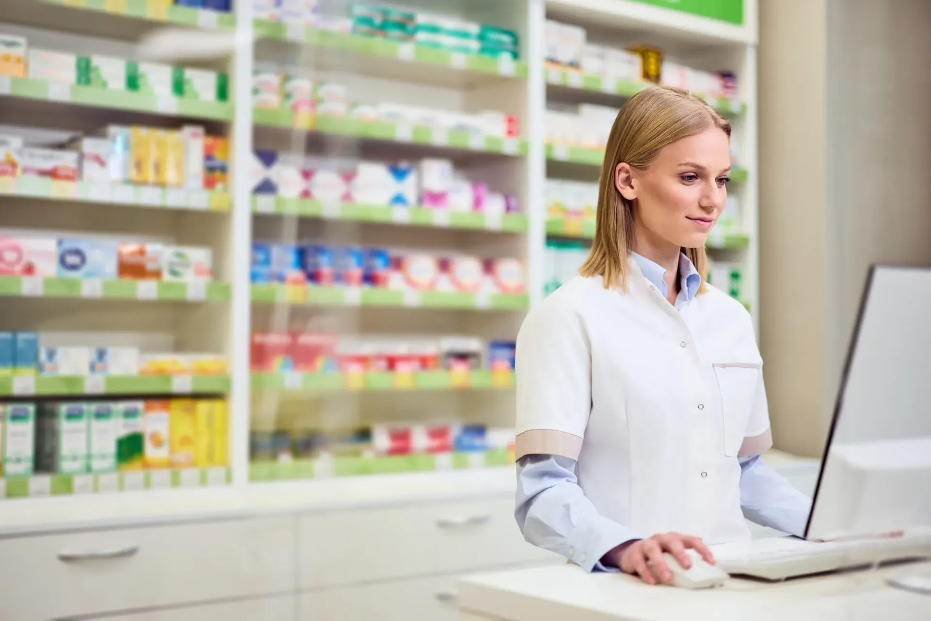 Pharmacist working at a computer in a pharmacy, Pan Pharmacy Birmingham