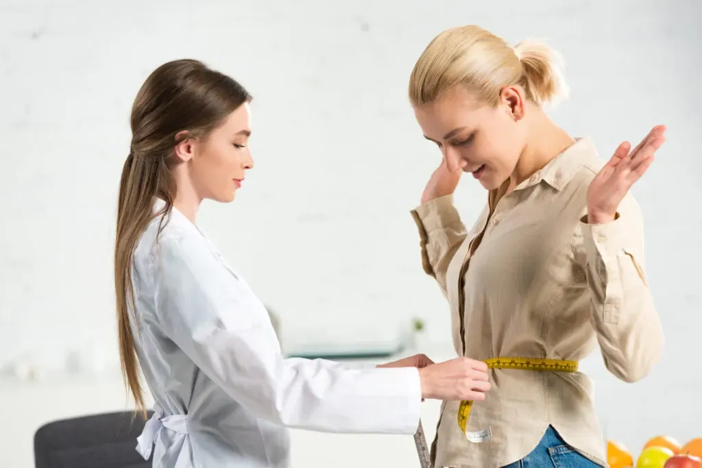 Practitioner measuring a woman’s waist during a weight loss consultation at Pan Pharmacy Birmingham
