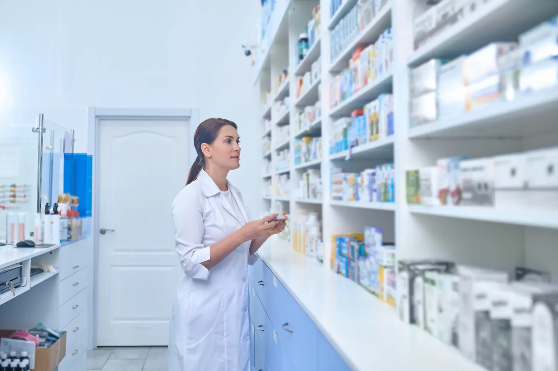 Pharmacist checking medicines on the pharmacy shelves at Pan Pharmacy Birmingham