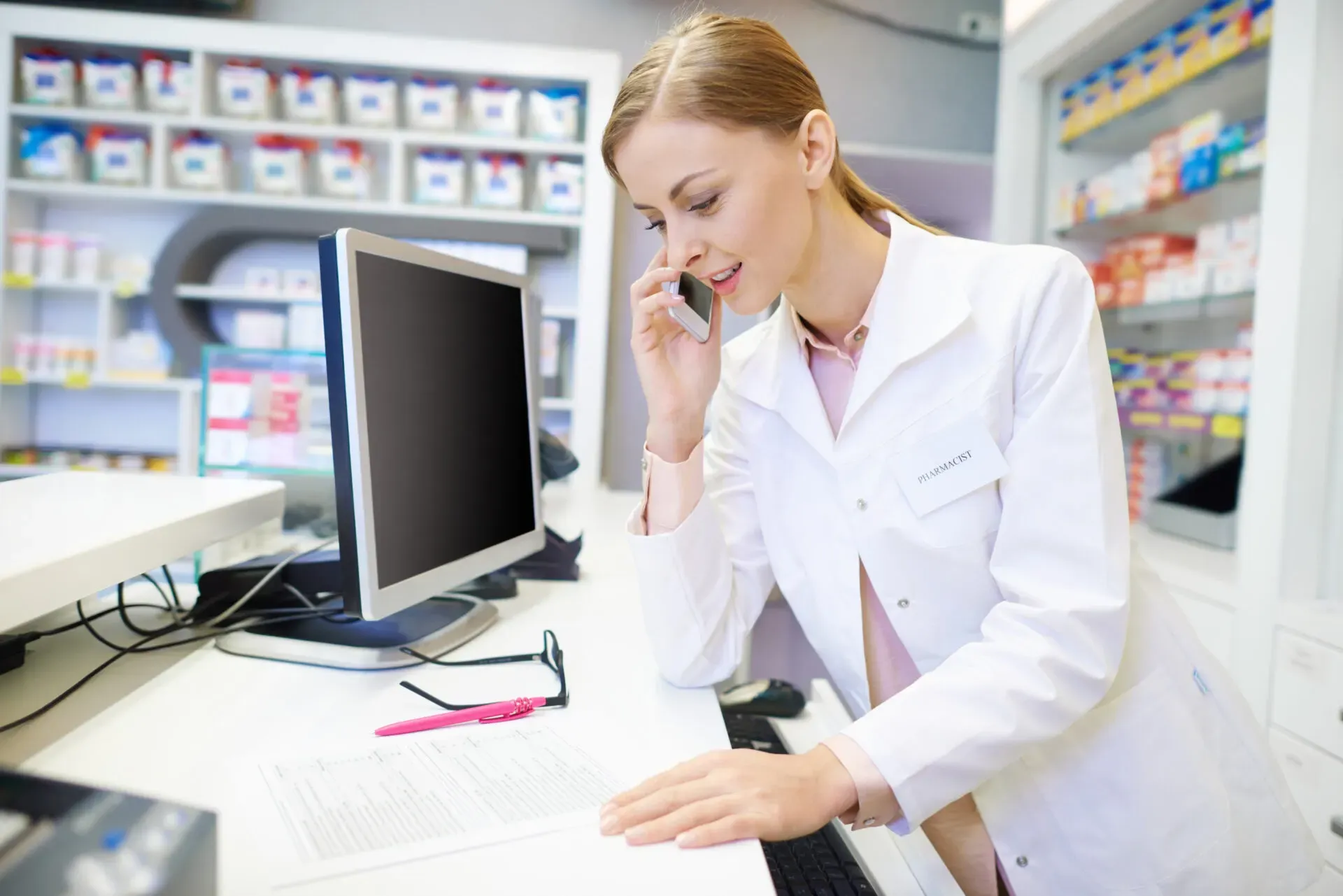 Pharmacist speaking to a patient on the phone at a computer, Pan Pharmacy Birmingham