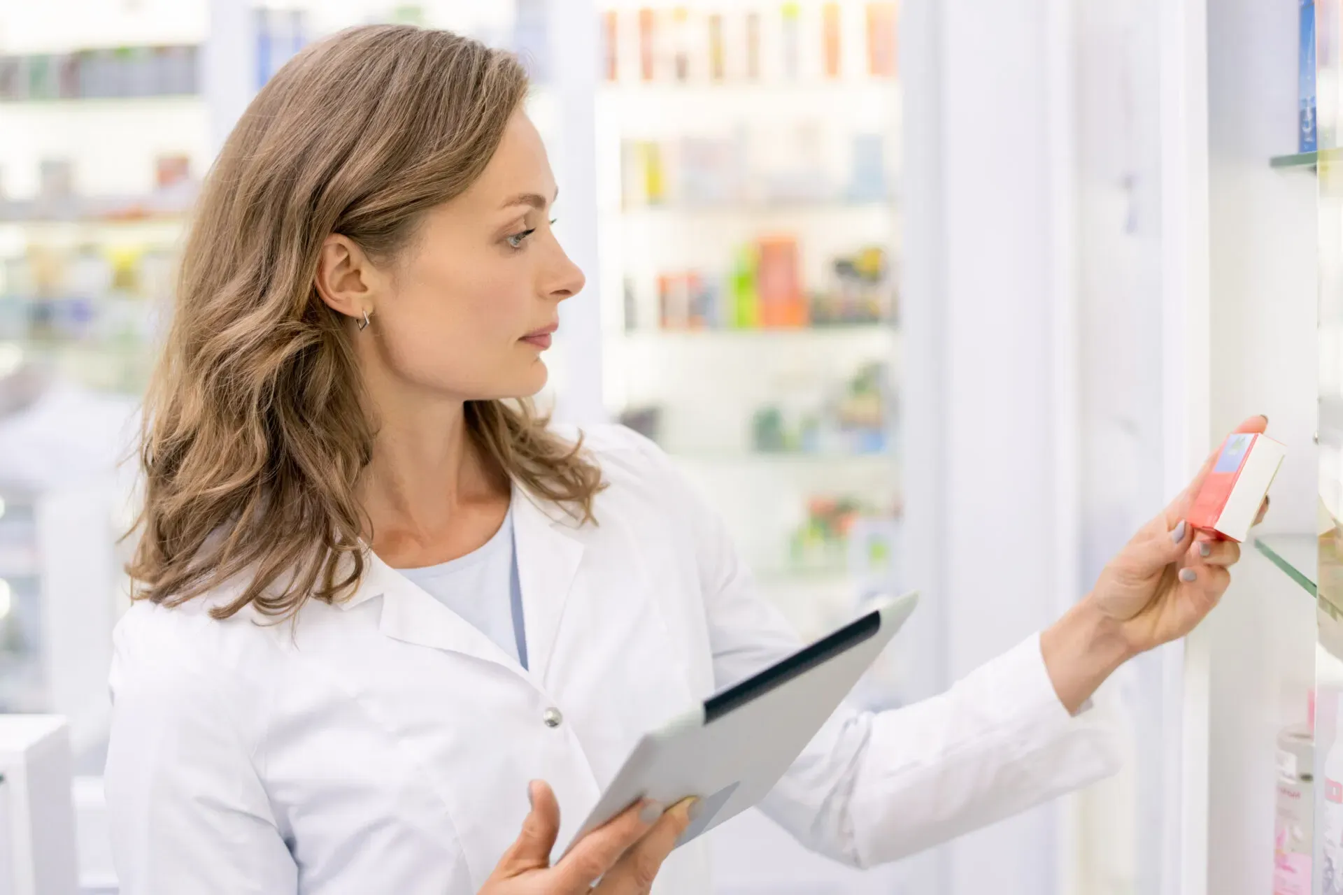 Pharmacist with a tablet inspecting medication on the shelves, Pan Pharmacy – Partridge Road
